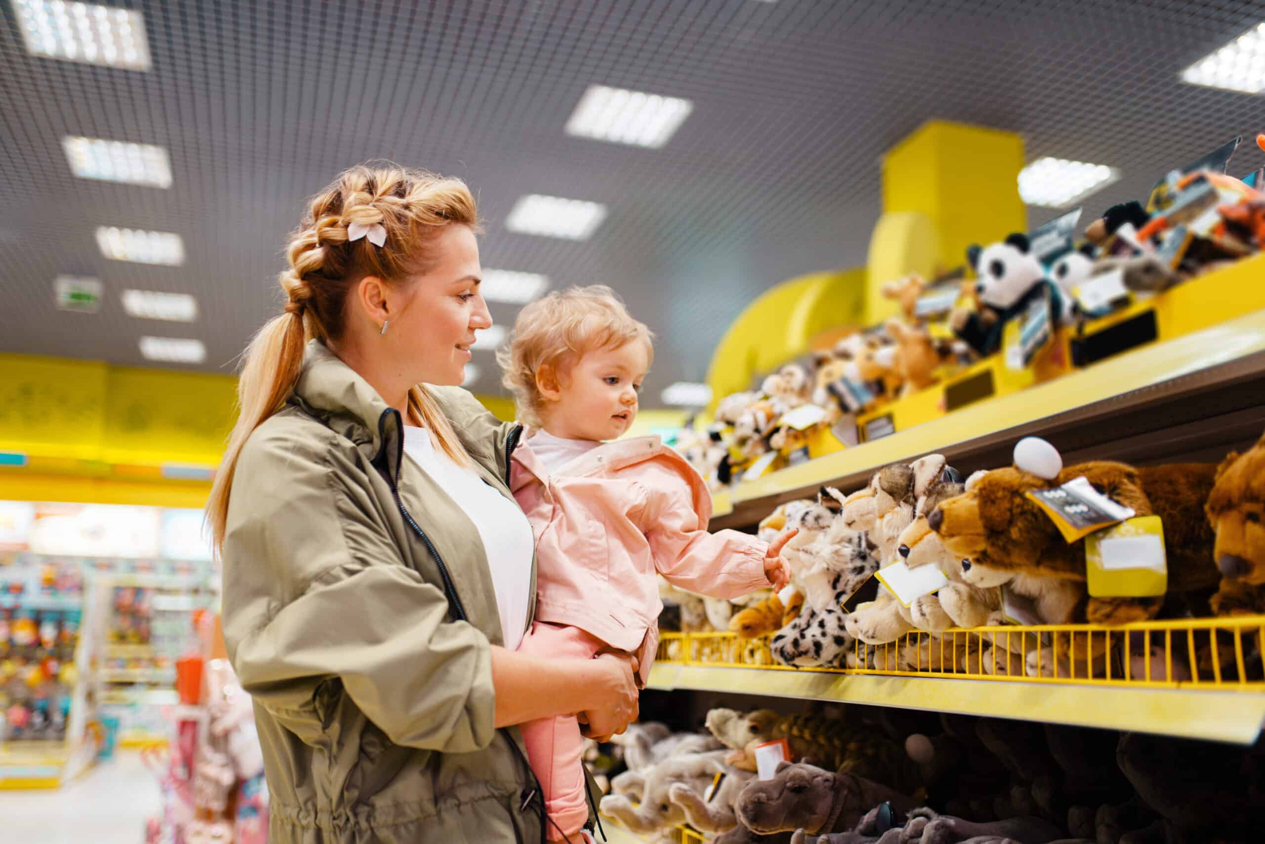 Science And Discovery Mother with her girl choosing toys in kids store